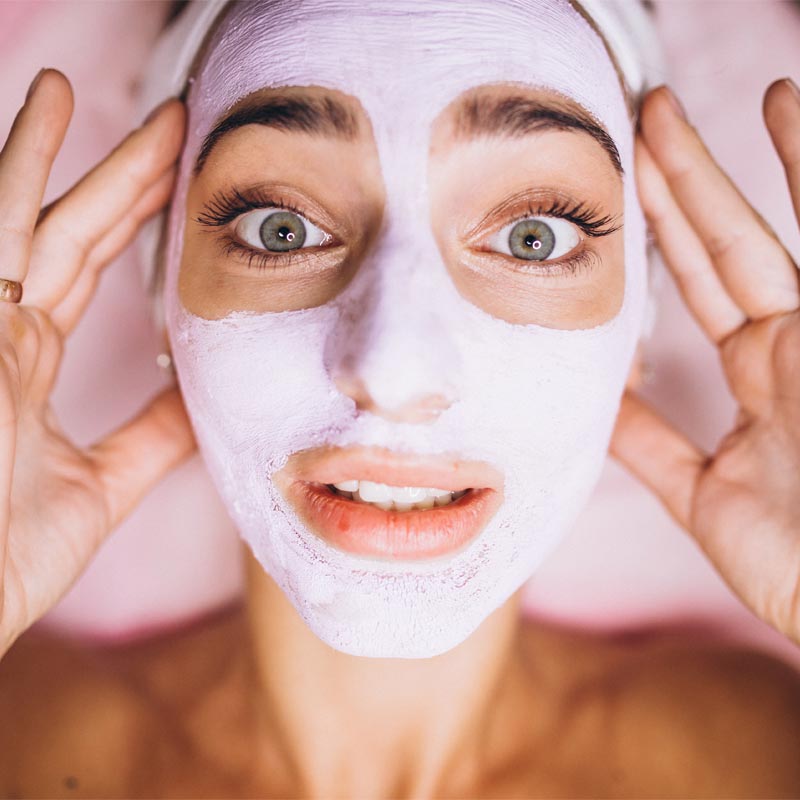 Massage du visage lors de l’application d’une crème anti-âge en institut